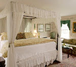 Beautiful spacious guest room with several windows and four poster bed with white canopy