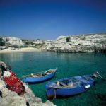 Two blue canoes along a rocky shore