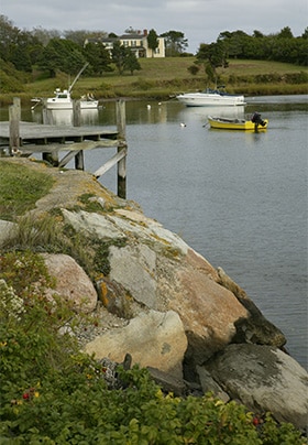 Water view from rocky edge with several boats 