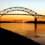 Cape Cod Bourne Bridge in the forefront and Railroad Bridge in the background amidst a sunset sky