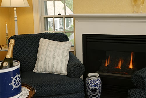 Clarissa Suite living room showing gas fireplace and blue cushioned rocking chair