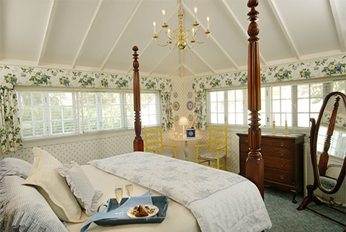 Clarissa Suite showing king bedroom in yellow, blue, and white with windows on three sides