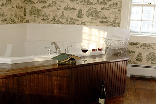 Eliza Jane Suite bathroom showing double whirlpool tub and red wine