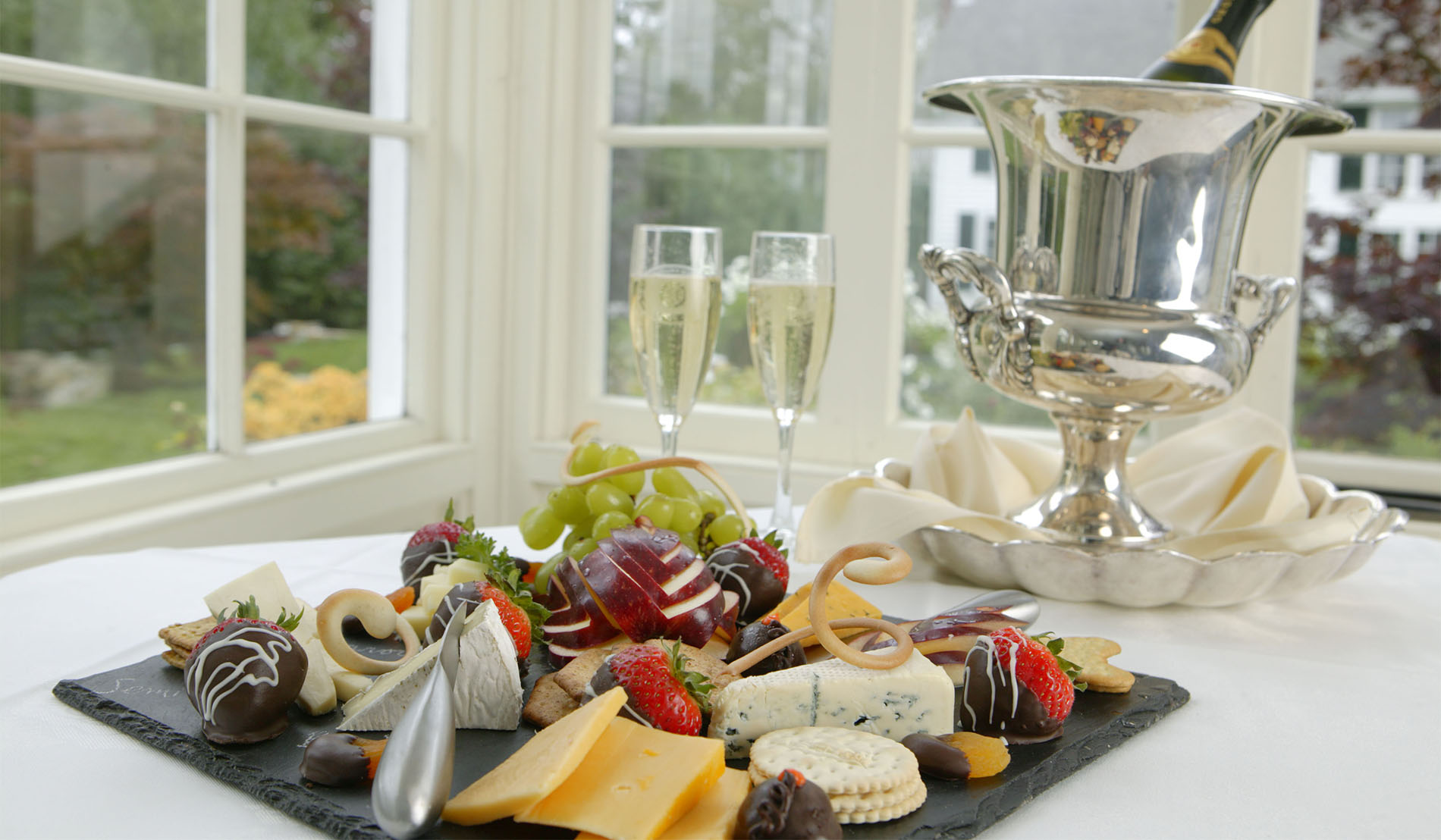 Romantic package in-room extra showing fruit, cheese, and chocolate dipped strawberry plate and champagne