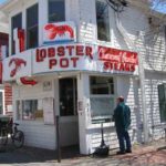 Exterior view of the Lobster Pot restaurant with white siding and green shutters