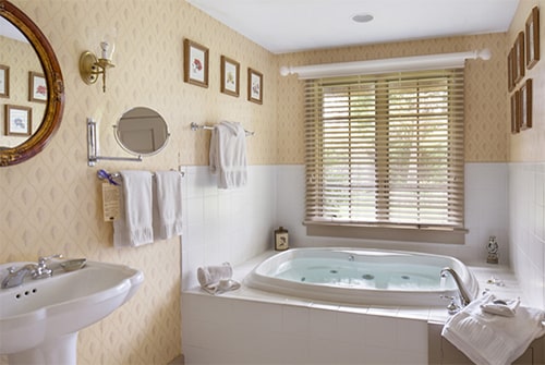 Northern Light whirlpool Jacuzzi tub with white tile deck and vanity sink with chrome fixtures