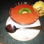 Glass dessert filled with strawberry gazpacho and kiwi slice