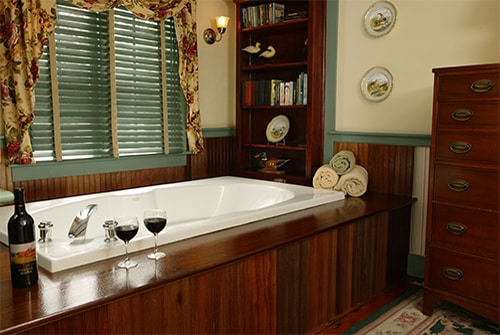 Tradewinds double soaking tub with wood deck surround and red wine