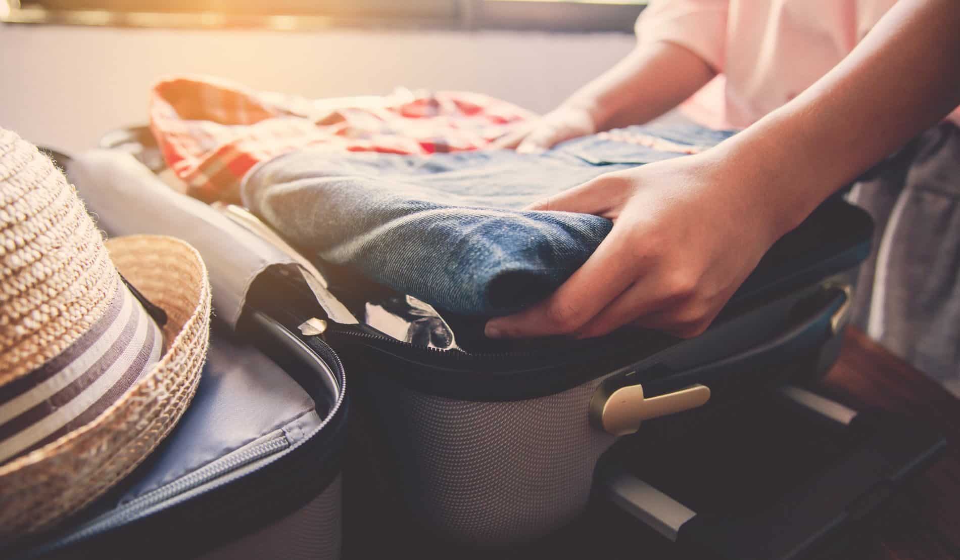 A person packing their luggage for a getaway