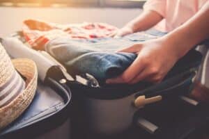 A person packing their luggage for a getaway