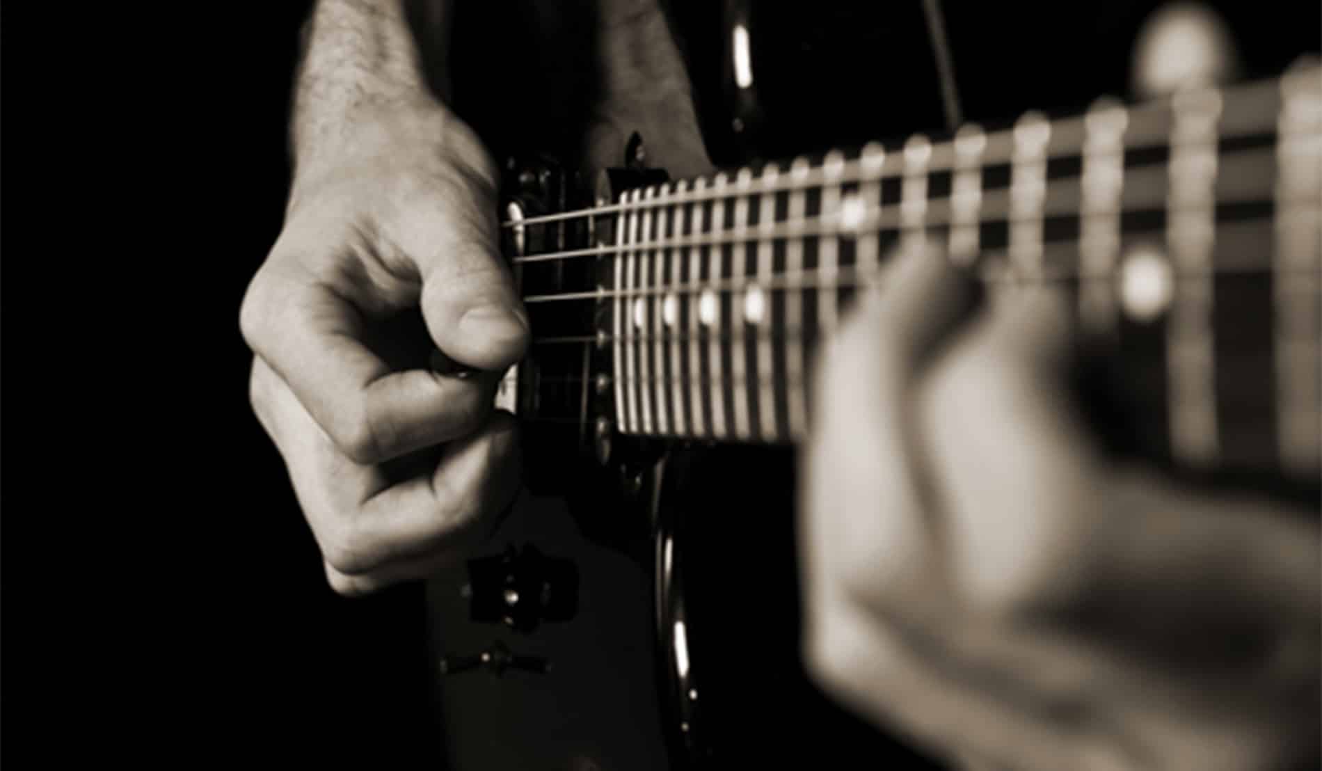close-up view of man playing a guitar