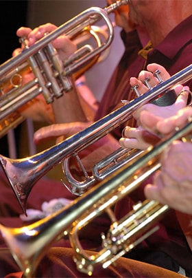 Close-up view of several people playing trumpets